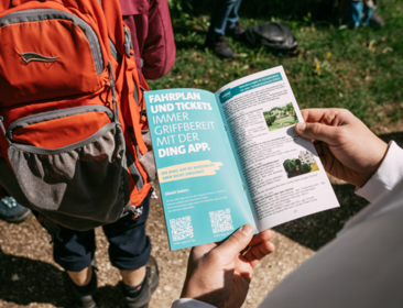 Person hält DING-Flyer